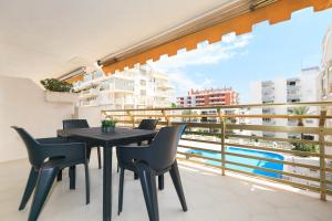 a balcony with a table and chairs and a view of the water at UHC Novelty Apartments in Salou