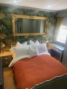 um quarto com uma cama grande e um espelho em Shelbourne House em Harrogate