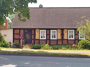 a brick house with white windows and a black door at Ferienwohnung Steffenshagen in Pritzwalk
