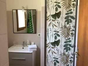 a bathroom with a sink and a shower curtain at la dolce farniente in Biaudos