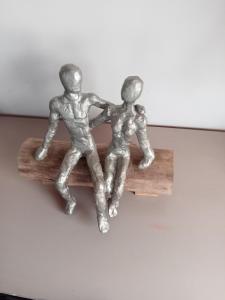 two metal figurines of two men sitting on a bench at Studio privatif in Guillestre