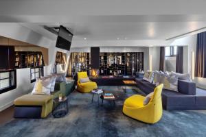 a living room with couches and yellow chairs at W Amsterdam in Amsterdam