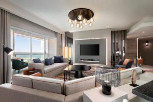 a living room with a couch and a tv at Sheraton Jeddah Hotel in Jeddah