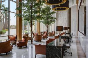فندق شيراتون جدة في جدة: لوبي فيه كراسي وطاولات ونوافذ