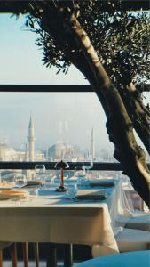 a table with wine glasses and a tree at Innova Sultanahmet Istanbul in Istanbul
