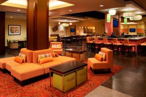 a hotel lobby with couches and tables and a bar at Buffalo Marriott Niagara in Amherst