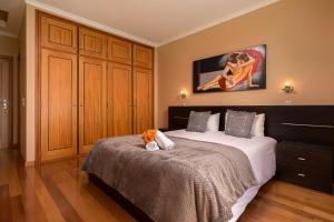 a bedroom with a bed with a stuffed animal on it at KING´S HOUSE (Sea View and Indoor BBQ) in Estreito da Calheta