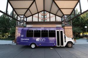 un bus violet garé devant un bâtiment dans l'établissement Sheraton Suites Philadelphia Airport, à Philadelphie