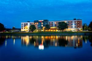 a building with a reflection in the water at night at Courtyard by Marriott Evansville East in Evansville