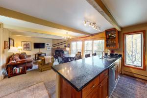 a kitchen with a counter top and a living room at Snowmas Village 20C in Snowmass Village