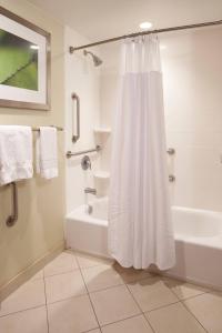 a bathroom with a shower curtain and a bath tub at Courtyard by Marriott Evansville East in Evansville