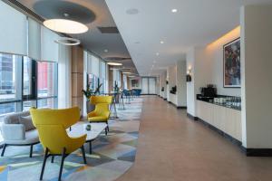 a hallway with chairs and a table in a building at Courtyard by Marriott Chisinau in Chişinău