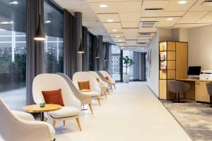 a row of chairs and tables in a waiting room at Courtyard Tampere City in Tampere