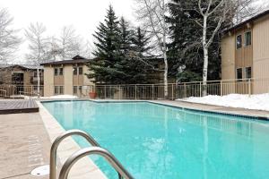 une grande piscine bleue avec de la neige au sol dans l'établissement Snowmas Village 20C, à Snowmass Village