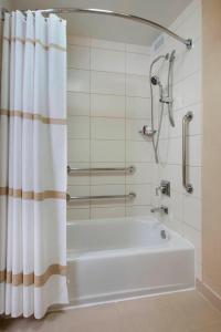 a white bath tub with a shower curtain in a bathroom at Chicago Marriott Oak Brook in Oak Brook