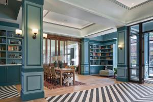 a room with blue walls and a dining room with a table at The Memphian a Tribute Portfolio Hotel in Memphis