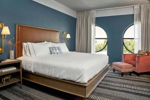 a bedroom with a large bed and a chair at The Memphian a Tribute Portfolio Hotel in Memphis