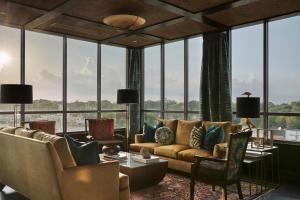 a living room with couches and chairs and windows at The Memphian a Tribute Portfolio Hotel in Memphis
