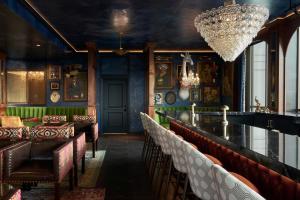 a bar with leather chairs and a chandelier at The Memphian a Tribute Portfolio Hotel in Memphis