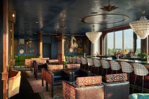 a restaurant with chairs and a bar in a room at The Memphian a Tribute Portfolio Hotel in Memphis