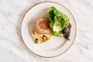 a sandwich and a salad on a white plate at The Memphian a Tribute Portfolio Hotel in Memphis