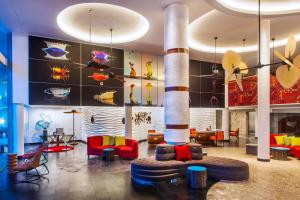 a lobby with a large room with colorful furniture at Le Meridien Bali Jimbaran in Jimbaran