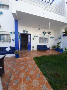 un salon avec des canapés bleus et une terrasse dans l'établissement Maison Azul, à Saïdia