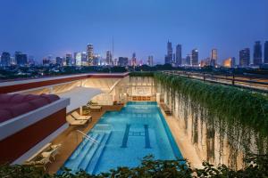 una piscina in cima a un edificio con vista sulla città di The Hermitage, A Tribute Portfolio Hotel, Jakarta a Giacarta