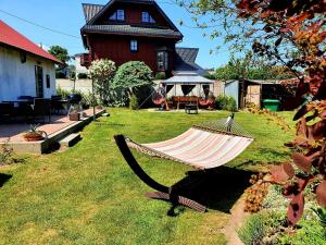 a hammock in a yard in front of a house at Pokoje nad morzem Mikoszewo in Nickelswalde