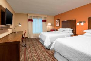 a hotel room with two beds and a flat screen tv at Four Points Bentonville in Bentonville
