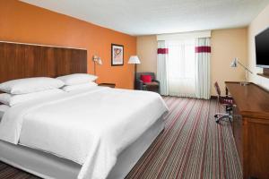 a hotel room with a large bed and a television at Four Points Bentonville in Bentonville