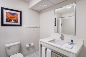 een witte badkamer met een wastafel en een spiegel bij Four Points Bentonville in Bentonville
