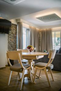 una mesa de comedor y sillas con un tazón en Black Rocks Luxury Seafront Beach Suite, en Agios Gordios
