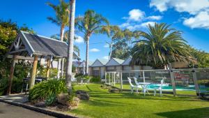 a house with a yard with a table and chairs at Tropicana Motor Inn in Cowes