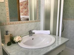 lavabo blanco en el baño con espejo en Villa Peonia, en Keszthely