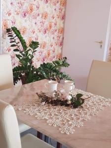 una mesa con dos tazas en un mantel de encaje en Villa Peonia, en Keszthely