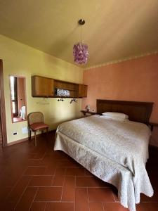 1 dormitorio con 1 cama grande y 1 silla en B&B L'angolo, en Cazzago San Martino