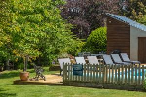 a wooden fence with lounge chairs in a yard at Luccombe Villa Holiday Apartments in Shanklin