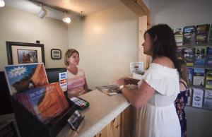 dos mujeres están de pie en un mostrador en una tienda en Alger Falls Motel, en Munising