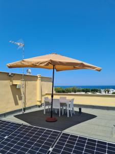 a table and chairs under an umbrella on a roof at La villetta vista mare in Bisceglie
