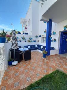 a patio with a couch and a table on a house at Maison Azul in Saidia 