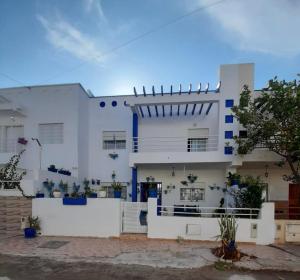 a white house with blue trim at Maison Belle Dune in Saïdia