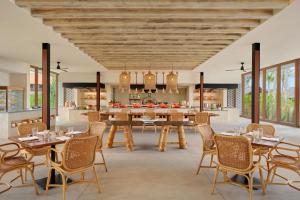 kuchnia na otwartym planie oraz jadalnia ze stołami i krzesłami w obiekcie Sheraton Belitung Resort w mieście Tanjungbinga
