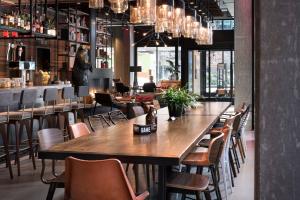 a dining room with a large wooden table and chairs at MOXY Seattle Downtown in Seattle