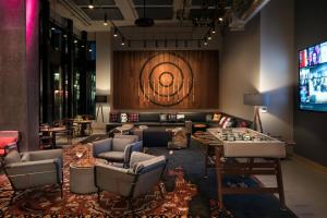 a room with couches and a table and a television at MOXY Seattle Downtown in Seattle
