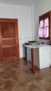 uma cozinha com um balcão e uma porta de madeira em Blue Sand 2 em Masouri
