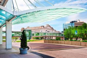 a glass building with a potted tree in a courtyard at The Westin Kansas City at Crown Center in Kansas City