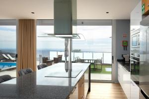 a kitchen with a counter with a view of the ocean at King´s Paradise (Heated Pool and Sea View) in Estreito da Calheta