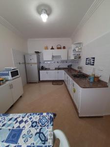 une cuisine avec des placards blancs et un comptoir dans l'établissement Maison Azul, à Saïdia