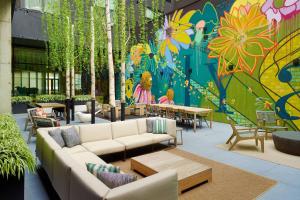a patio with couches and tables and a colorful mural at Bellyard, West Midtown Atlanta, a Tribute Portfolio Hotel in Atlanta
